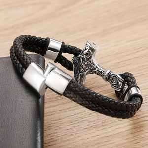 Detail of Viking Thor Hammer Mjölnir charm and braided leather cord on a men's bracelet