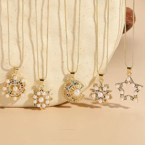 Star snowflake zircon pearl necklaces with gold plating shown on ceramic display