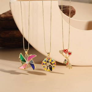 Detailed shot of gold-plated windmill, Egyptian cat, and bear pendants on a minimalist stand