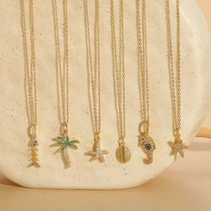 Detailed view of six ocean-themed gold necklaces with zircon palm trees, shells and sea stars