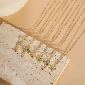 Detailed macro view of 14K gold plated ocean pendants including starfish and palm tree charms