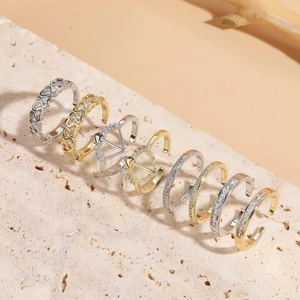 Ensemble de bagues géométriques dorées et argentées avec zircons sur socle en pierre