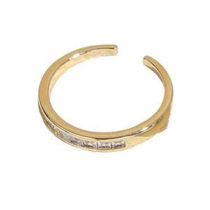 Bague ouverte dorée élégante ornée d'une rangée de pierres en zircone cubique