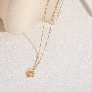 Detail of gold heart pendant with zircon inlay and relief bear on O-chain necklace