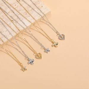 Macro shot of gold and silver necklaces with zircon star and windmill heart pendants