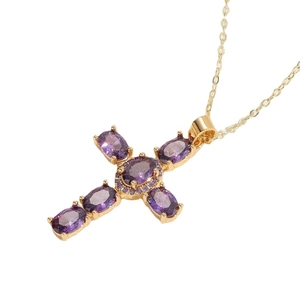 Collar con colgante de cruz chapado en oro de 14K con piedras de circón púrpura en fondo blanco