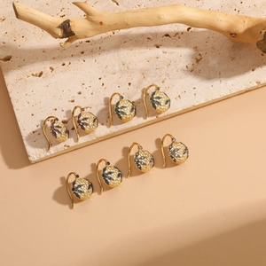 Detailed shot of vintage zircon earrings with multi-color stones and hammered texture finish