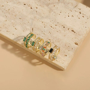 Vue détaillée de quatre bagues plaquées or 14K avec zircons rectangulaires colorés