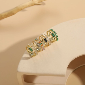 Vue détaillée de quatre bagues empilables plaquées or 14K avec zircons verts et clairs