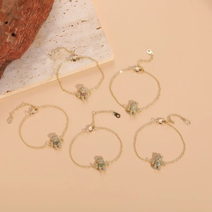 Détail de cinq pendentifs ours en or 14K avec des pierres précieuses en zircon coloré