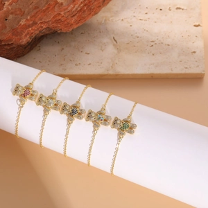 Détails de bracelets dorés avec oursons sertis de zircons colorés sur présentoir
