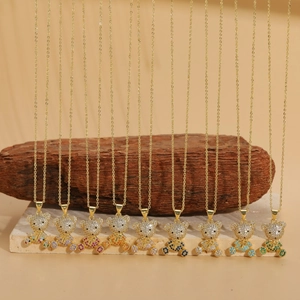 Set of 10 gold plated bear necklaces with colorful zircon stones on rustic wood