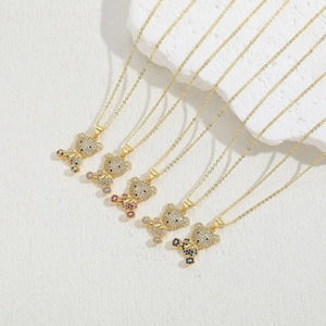 5 Luxury 14K gold plated teddy bear pendants with colorful zircons on white stone background