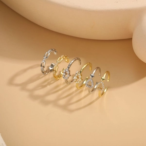 Vista detallada del set de anillos ajustables en oro y plata con corazones de circón
