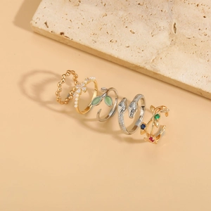Close-up of a 5-piece jewelry set featuring silver snake ring and cat eye zircon rings