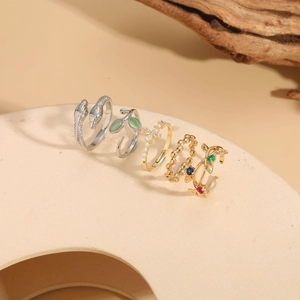 Detailed view of snake-shaped and floral rings set with zircon and pearls on display
