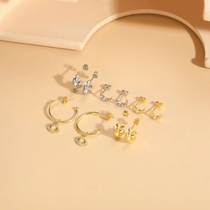Detail of moon and opal eye earrings with gold plating on minimalist display blocks