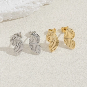 Detail of gold and silver butterfly wing earrings with intricate textured engravings