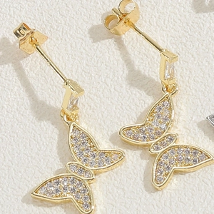 Detailed close-up of 14K gold butterfly earrings with micro-paved sparkling zircon stones