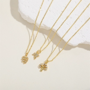 Detailed view of 14K gold leaf and tree of life pendants with zircon micro-pave setting