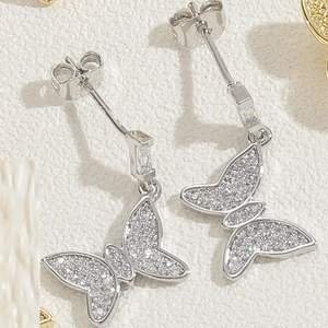 Close-up of butterfly drop earrings with cubic zirconia pavé and silver finish links
