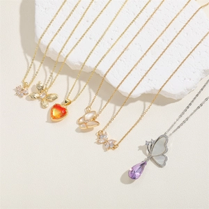 Détail de divers pendentifs papillon et cœur avec zircon et textures de nacre sur pierre