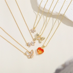 Ensemble de colliers superposés dorés avec pendentifs papillon et cœur orange