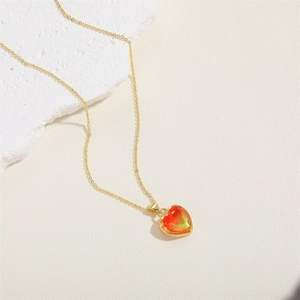 Détail du collier avec pendentif cœur en pierre dégradée et chaîne dorée élégante