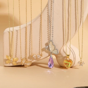 Colliers raffinés en zircon avec papillon et cœur en finitions or et argent sur un support