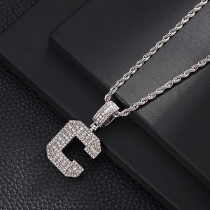 Vue macro du pendentif lettre C serti de zircons avec une chaîne torsadée style hip hop