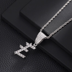 Macro-opname van zilveren letter E-hanger met zirkonia aan een gedraaide schakelketting