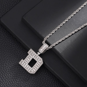 Détail macro du collier hip hop argenté avec pendentif en D et zircons pavés