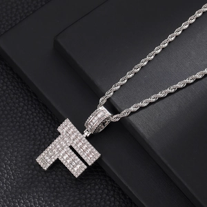 Détail macro du pendentif lettre F en argent avec zircons cubiques sur chaîne corde