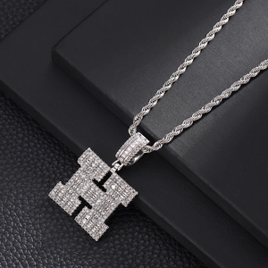 Vue macro du pendentif lettre H hip hop argenté avec zircons brillants sur chaîne