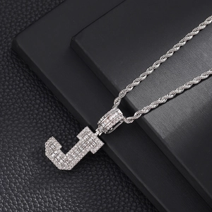 Vue macro du pendentif Hip Hop lettre J argenté avec zircons et chaîne torsadée