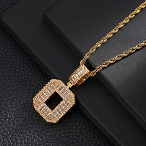 Macro shot of gold twist chain necklace with square zircon iced out letter pendant