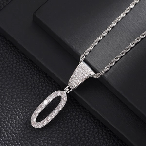 Macro-opname van zilveren hiphop-hanger met witte zirkonen aan een dikke gedraaide ketting