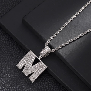 Détail du pendentif lettre M hip hop glacé avec zircons carrés et chaîne de corde argentée