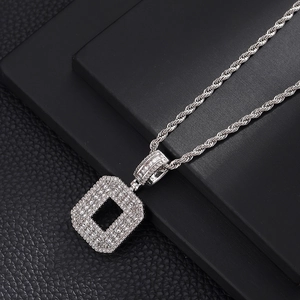 Macro d'un collier hip-hop argenté avec pendentif en zircons sur une chaîne torsadée