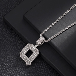 Gros plan du pendentif lettre Q en argent avec oxydes de zirconium et chaîne torsadée