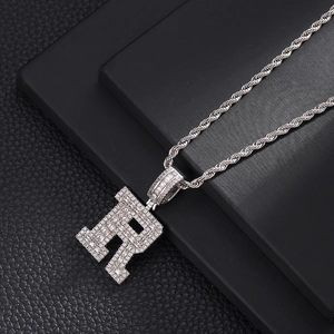 Vue macro d'un pendentif lettre R en argent avec diamants baguette et pavé sertis