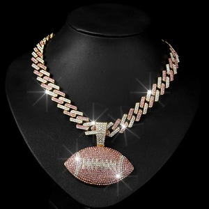 Close-up of hip hop gold Cuban chain necklace with iced out pink and white football pendant