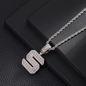 Vue macro du pendentif Hip Hop lettre S argenté avec pavage de zircons étincelants
