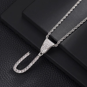 Macro-opname van de letter U-hanger met glanzende zirkonia en een zilveren gedraaide ketting