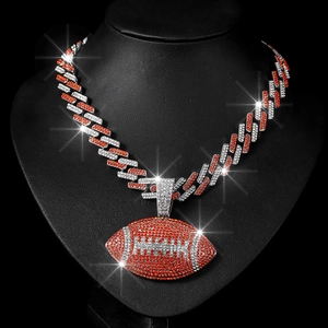 Macro shot of hip hop cuban link chain with iced out orange rhinestone rugby pendant