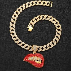 Macro-opname van de met kristallen bezette rode lippen hanger op een gouden cuban ketting