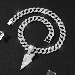 Macro shot of a silver Cuban chain with a diamond-encrusted lightning bolt pendant