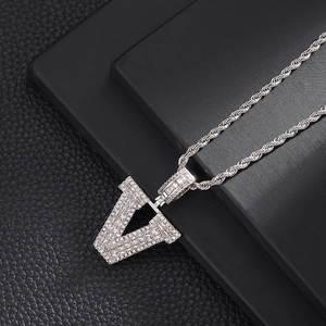 Détail du pendentif lettre V en argent serti de zircones avec chaîne torsadée hip-hop