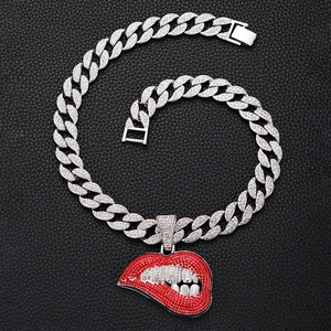 Macro-opname van hiphop Cubaanse ketting met fonkelende rode lippen hanger en strass