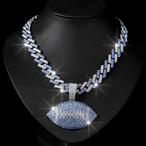 Macro detail of iced out Cuban chain with blue rhinestones and football pendant